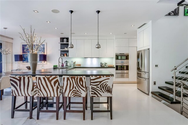 2000 S Bayshore Dr Unit 47, Miami, FL 33133 - kitchen featuring stainless steel appliances, modern cabinets, white cabinets, dark countertops, and decorative light fixtures