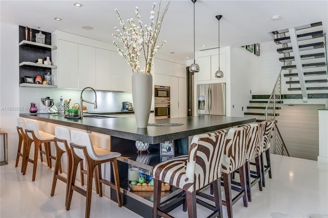 2000 S Bayshore Dr Unit 47, Miami, FL 33133 - kitchen with stainless steel appliances, dark countertops, a peninsula, and white cabinets