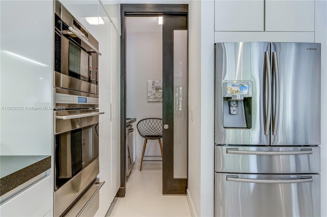 2000 S Bayshore Dr Unit 47, Miami, FL 33133 - kitchen featuring stainless steel appliances, white cabinetry, a warming drawer, and modern cabinets