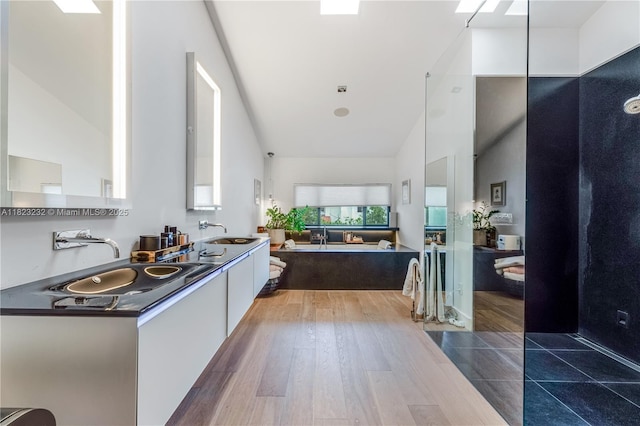 2000 S Bayshore Dr Unit 47, Miami, FL 33133 - bathroom featuring high vaulted ceiling, a garden tub, double vanity, and wood finished floors