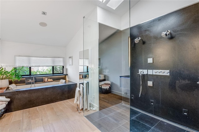 2000 S Bayshore Dr Unit 47, Miami, FL 33133 - bathroom featuring high vaulted ceiling, a bath, wood finished floors, a skylight, and a shower