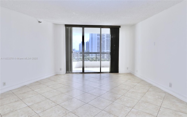3500 Mystic Pointe Dr Unit 1207, Aventura, FL 33180 - empty room with expansive windows, a textured ceiling, and light tile patterned flooring
