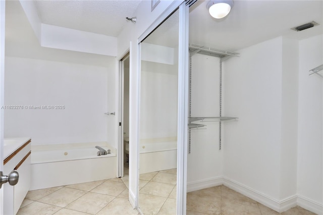 3500 Mystic Pointe Dr Unit 1207, Aventura, FL 33180 - full bath featuring a garden tub, vanity, a spacious closet, and tile patterned flooring