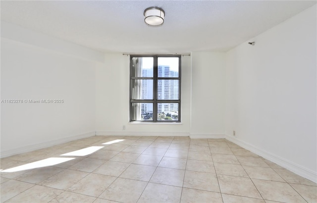 3500 Mystic Pointe Dr Unit 1207, Aventura, FL 33180 - spare room featuring light tile patterned floors and baseboards