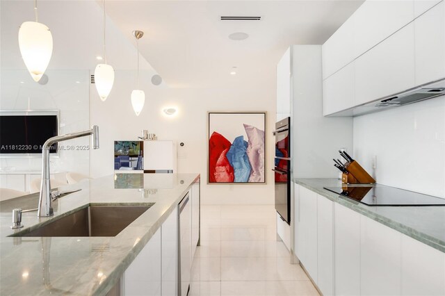 480 NE 31st St Unit 3802, Miami, FL 33137 - kitchen with black electric stovetop, modern cabinets, and white cabinetry