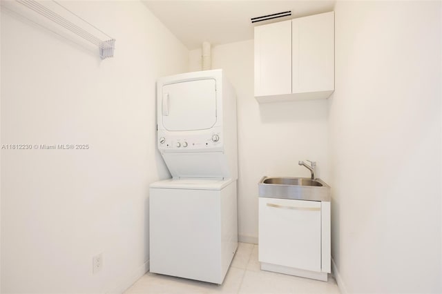 480 NE 31st St Unit 3802, Miami, FL 33137 - washroom with stacked washer / drying machine, cabinet space, and light tile patterned floors