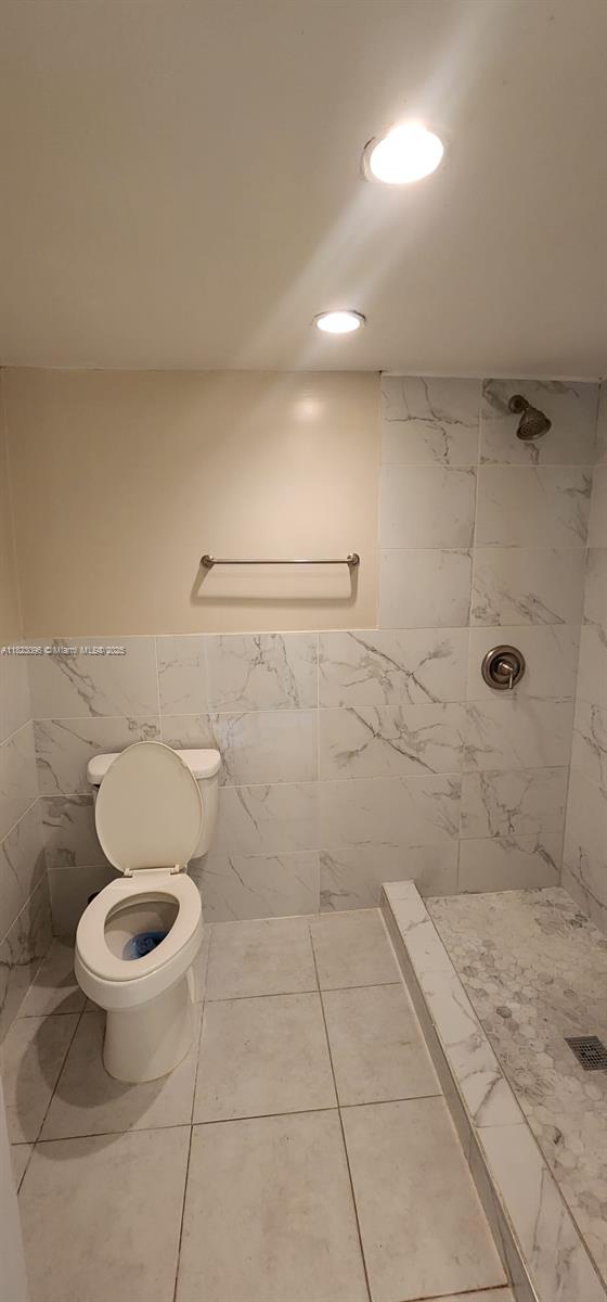 14830 Naranja Lakes Blvd Unit A1B, Homestead, FL 33032 - bathroom featuring a tile shower, tile walls, a wainscoted wall, and recessed lighting