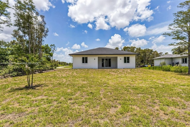 337 Jourferie Rd, Lehigh Acres, FL 33974 - rear view of house with french doors, a lawn, and stucco siding