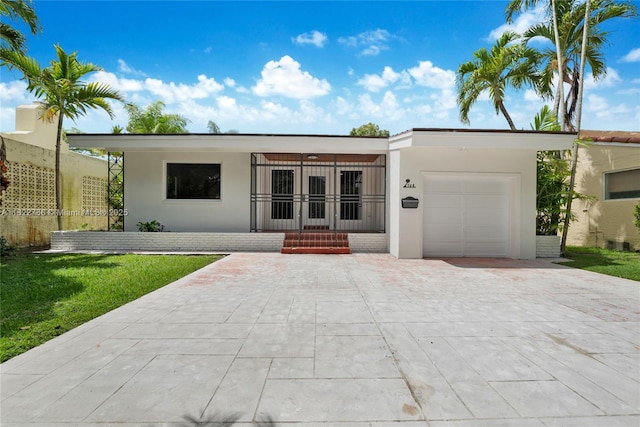 708 Navarre Ave, Coral Gables, FL 33134 - view of front of property featuring driveway, a garage, stucco siding, and a front lawn