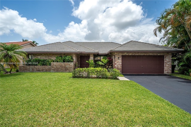851 Altavista Ter, Davie, FL 33325 - view of front of property featuring asphalt driveway, an attached garage, a front lawn, brick siding, and a tiled roof