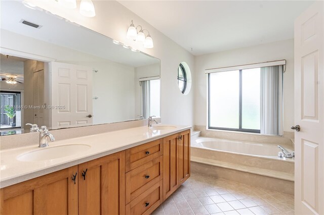 851 Altavista Ter, Davie, FL 33325 - bathroom with plenty of natural light, double vanity, a garden tub, and tile patterned floors