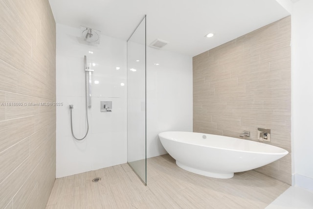 300 Sunny Isles Blvd Unit 4-2303, Sunny Isles Beach, FL 33160 - bathroom with tile walls, a soaking tub, and a walk in shower