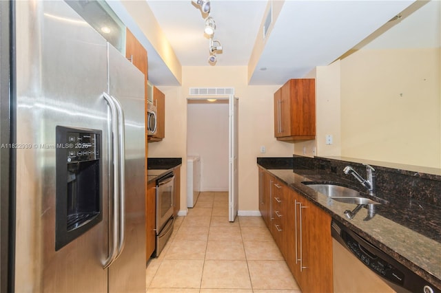 7350 SW 89th St Unit 602S, Miami, FL 33156 - kitchen featuring appliances with stainless steel finishes, brown cabinets, light tile patterned floors, and washer / dryer