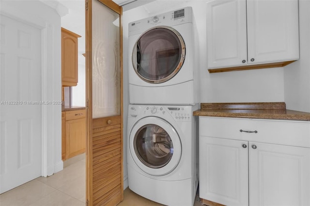 12440 SW 207th Ter, Miami, FL 33177 - laundry room with stacked washing machine and dryer, cabinet space, and light tile patterned floors