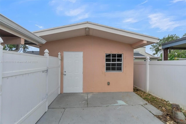 12440 SW 207th Ter, Miami, FL 33177 - view of exterior entry with stucco siding and a patio