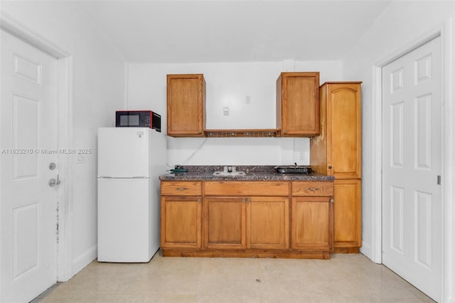 12440 SW 207th Ter, Miami, FL 33177 - kitchen featuring freestanding refrigerator, black microwave, brown cabinets, dark countertops, and light tile patterned floors