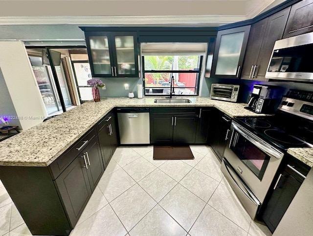 2433 NW 92nd Ave, Coral Springs, FL 33065 - kitchen with appliances with stainless steel finishes, crown molding, light tile patterned flooring, light stone countertops, and a peninsula