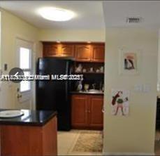 2910 Point E Dr Unit M610, Aventura, FL 33160 - kitchen with dark countertops and brown cabinetry
