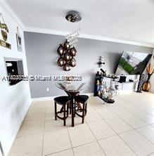 2910 Point E Dr Unit M610, Aventura, FL 33160 - dining space with tile patterned flooring, a chandelier, and ornamental molding
