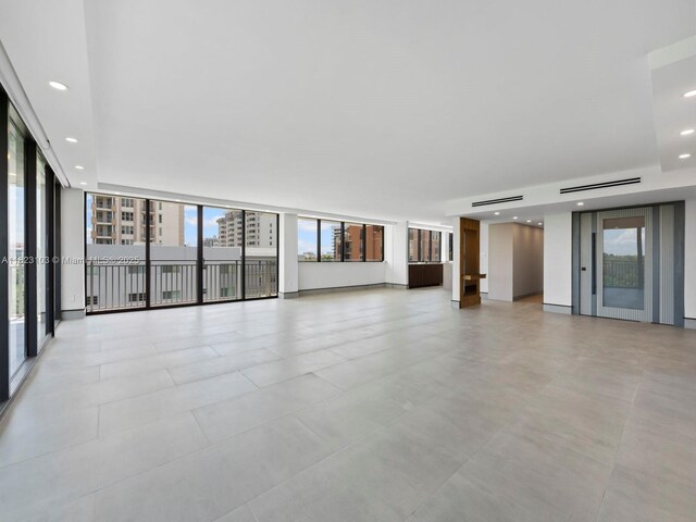 700 Coral Way Unit 5, Coral Gables, FL 33134 - unfurnished living room featuring plenty of natural light, recessed lighting, and a wall of windows