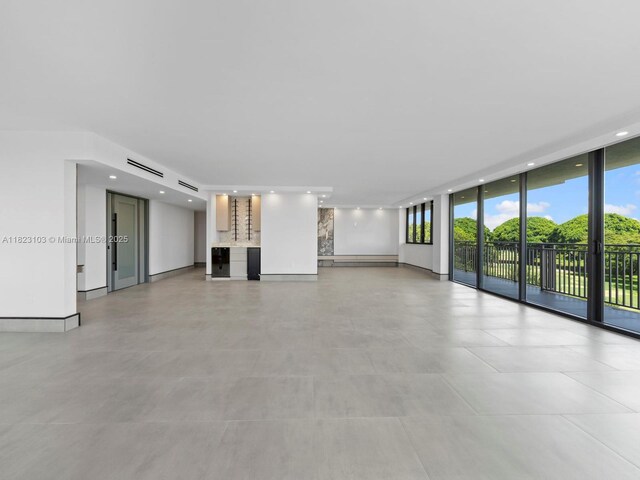 700 Coral Way Unit 5, Coral Gables, FL 33134 - unfurnished living room featuring a wall of windows and recessed lighting