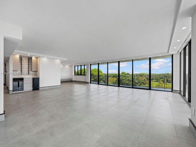 700 Coral Way Unit 5, Coral Gables, FL 33134 - unfurnished living room with a wall of windows, beverage cooler, healthy amount of natural light, recessed lighting, and a dry bar