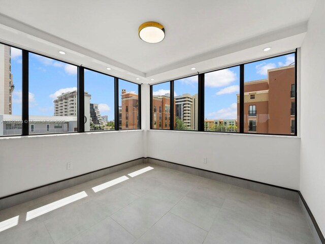 700 Coral Way Unit 5, Coral Gables, FL 33134 - spare room with healthy amount of natural light, a city view, tile patterned flooring, and recessed lighting