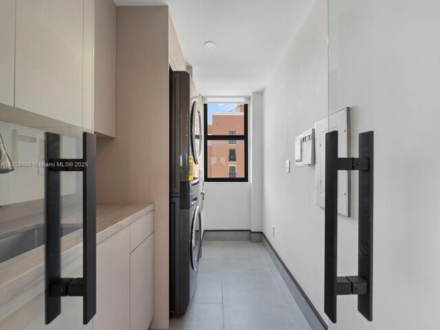 700 Coral Way Unit 5, Coral Gables, FL 33134 - laundry room featuring stacked washer and clothes dryer and cabinet space