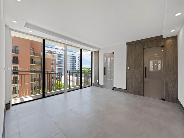 700 Coral Way Unit 5, Coral Gables, FL 33134 - tiled spare room featuring expansive windows and recessed lighting