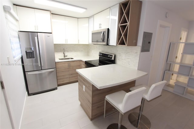 427 Santander Ave Unit 202, Coral Gables, FL 33134 - kitchen with appliances with stainless steel finishes, electric panel, tasteful backsplash, and a peninsula