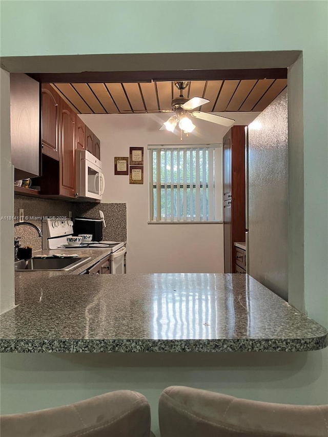 8605 W Sample Rd Unit 101, Coral Springs, FL 33065 - kitchen with white appliances, dark countertops, ceiling fan, a peninsula, and wooden ceiling