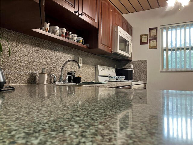 8605 W Sample Rd Unit 101, Coral Springs, FL 33065 - kitchen featuring white microwave, backsplash, stove, open shelves, and a ceiling fan