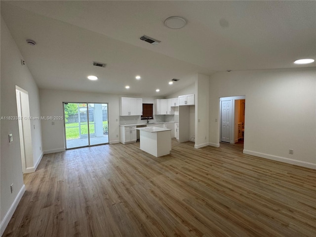737 SE Brookedge Ave, Port St Lucie, FL 34983 - unfurnished living room featuring vaulted ceiling, light wood finished floors, and recessed lighting