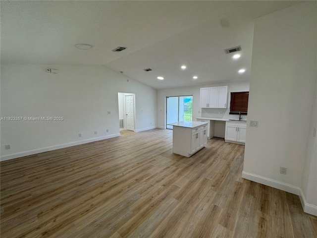 737 SE Brookedge Ave, Port St Lucie, FL 34983 - unfurnished living room with light wood finished floors, lofted ceiling, and recessed lighting