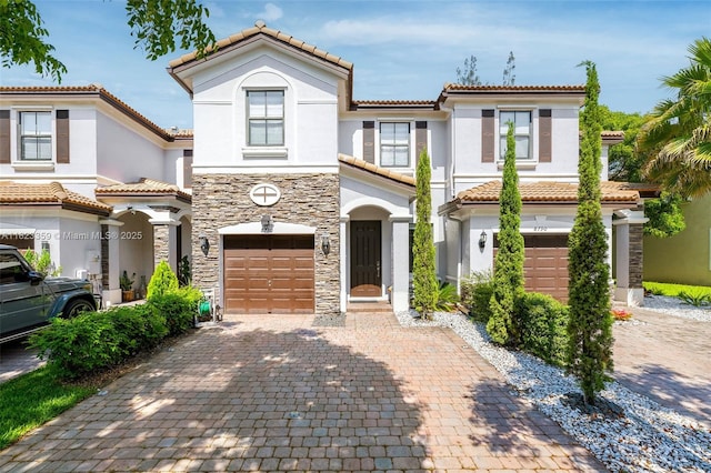 8780 NW 116th Path, Doral, FL 33178 - view of front of home with an attached garage, decorative driveway, stucco siding, a tile roof, and stone siding