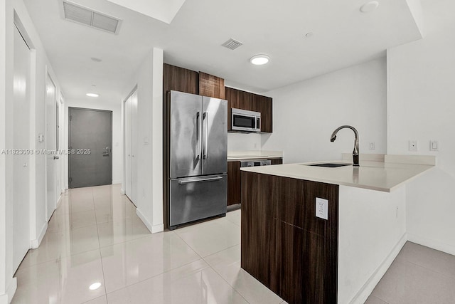 488 NE 18th St Unit 3105, Miami, FL 33132 - kitchen featuring appliances with stainless steel finishes, modern cabinets, light tile patterned flooring, dark brown cabinetry, and light countertops