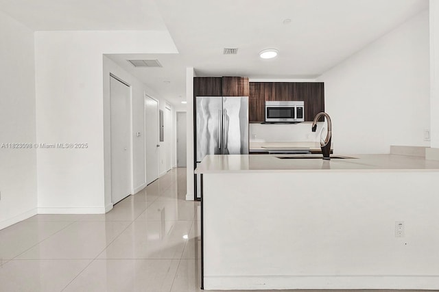 488 NE 18th St Unit 3105, Miami, FL 33132 - kitchen featuring appliances with stainless steel finishes, light countertops, light tile patterned floors, and a peninsula