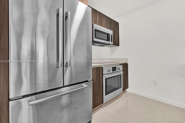 488 NE 18th St Unit 3105, Miami, FL 33132 - kitchen with stainless steel appliances, modern cabinets, light countertops, light tile patterned flooring, and dark brown cabinetry