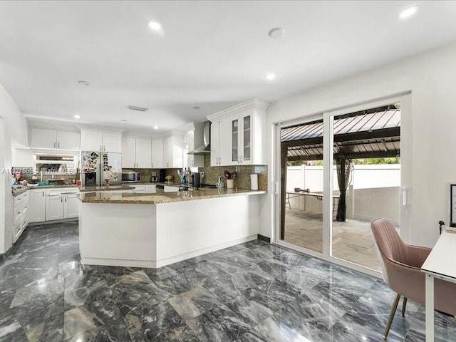 1870 NE 208th Ter, Miami, FL 33179 - kitchen with wall chimney range hood, decorative backsplash, light stone countertops, recessed lighting, and glass insert cabinets