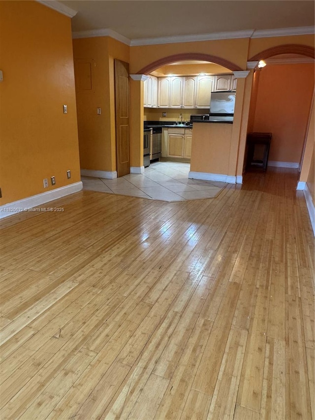 901 NE 3rd St Unit 302, Fort Lauderdale, FL 33301 - kitchen featuring arched walkways, ornamental molding, dark countertops, open floor plan, and light wood finished floors