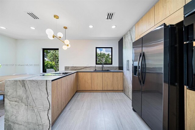 51 NE 110th St, Miami Shores, FL 33161 - kitchen with stainless steel refrigerator with ice dispenser, light stone countertops, modern cabinets, a peninsula, and plenty of natural light