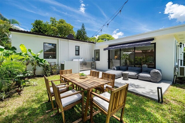 51 NE 110th St, Miami Shores, FL 33161 - back of house featuring a patio, stucco siding, outdoor dining space, a yard, and an outdoor kitchen