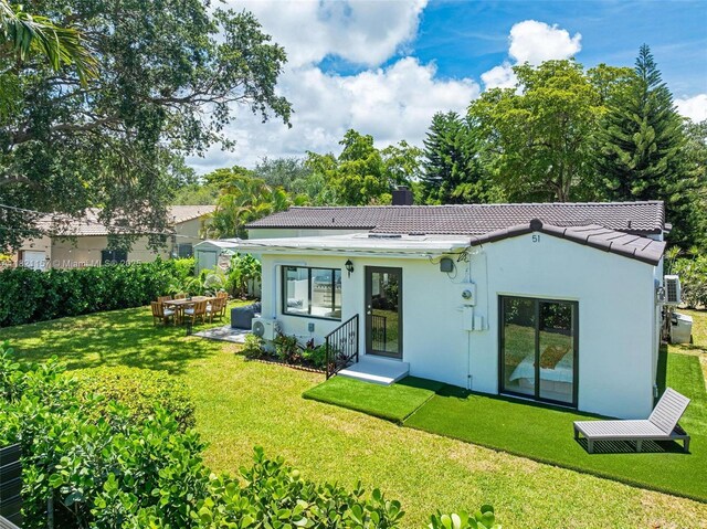 51 NE 110th St, Miami Shores, FL 33161 - back of property featuring a yard, a tiled roof, stucco siding, and a chimney