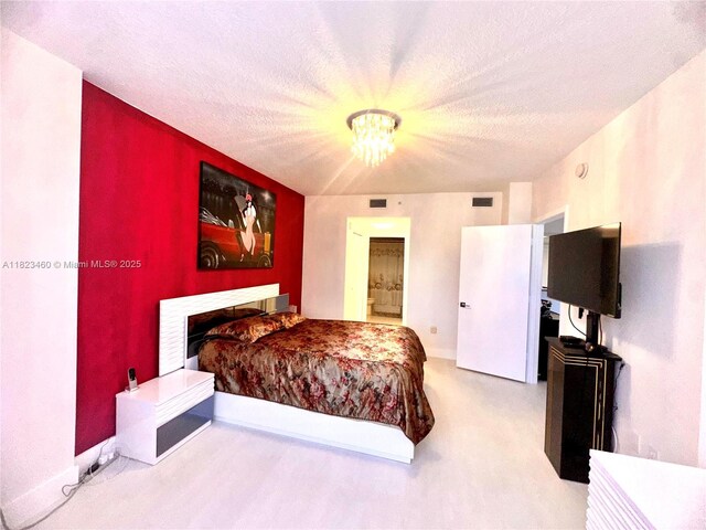 18800 NE 29th Ave Unit 412, Aventura, FL 33180 - carpeted bedroom featuring a chandelier, ensuite bath, and a textured ceiling