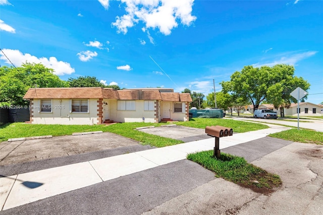 201 Columbus Pkwy, Hollywood, FL 33021 - ranch-style home featuring a front lawn, uncovered parking, mansard roof, and stucco siding