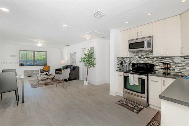 201 Columbus Pkwy, Hollywood, FL 33021 - kitchen featuring stainless steel appliances, dark countertops, tasteful backsplash, light wood finished floors, and recessed lighting