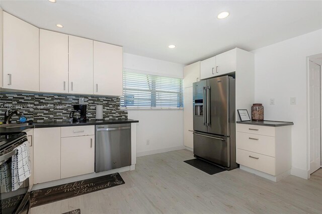201 Columbus Pkwy, Hollywood, FL 33021 - kitchen with appliances with stainless steel finishes, dark countertops, light wood-style floors, decorative backsplash, and recessed lighting