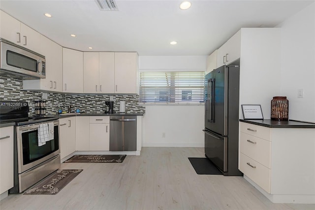 201 Columbus Pkwy, Hollywood, FL 33021 - kitchen featuring stainless steel appliances, dark countertops, light wood-style flooring, tasteful backsplash, and recessed lighting