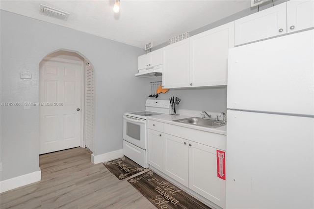 201 Columbus Pkwy, Hollywood, FL 33021 - kitchen featuring white appliances, light wood-style flooring, arched walkways, white cabinetry, and light countertops