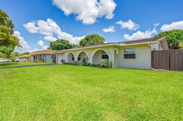 ranch-style house featuring stucco siding, an attached garage, and asphalt driveway